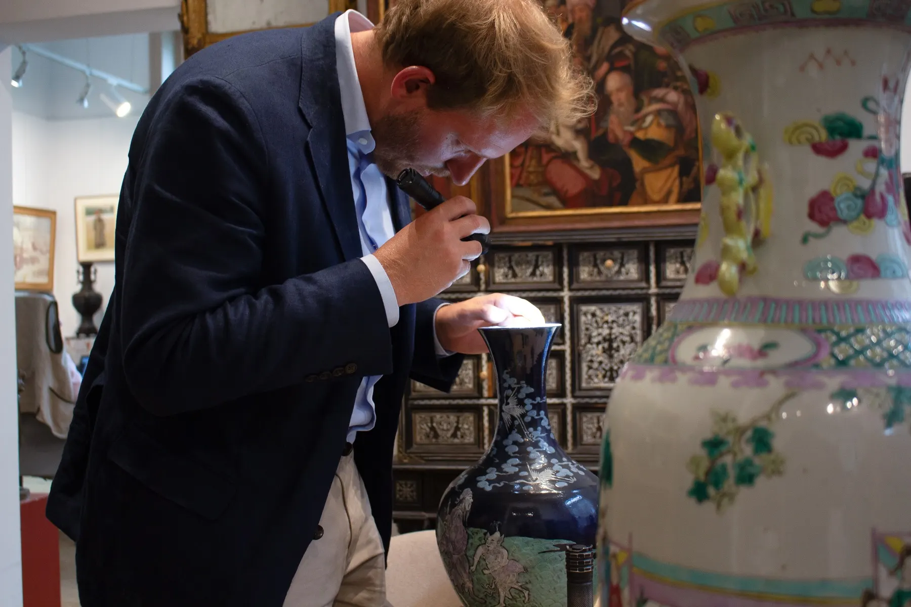 Notre expert en art asiatique dans notre showroom, entouré de porcelaines de Chine
